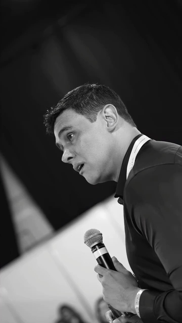 Black and white studio shot of a speaker at a microphone