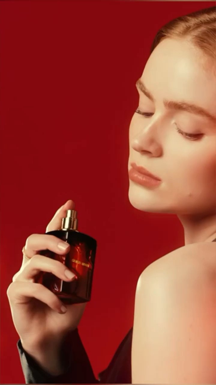 Fragrance product shot against a red backdrop